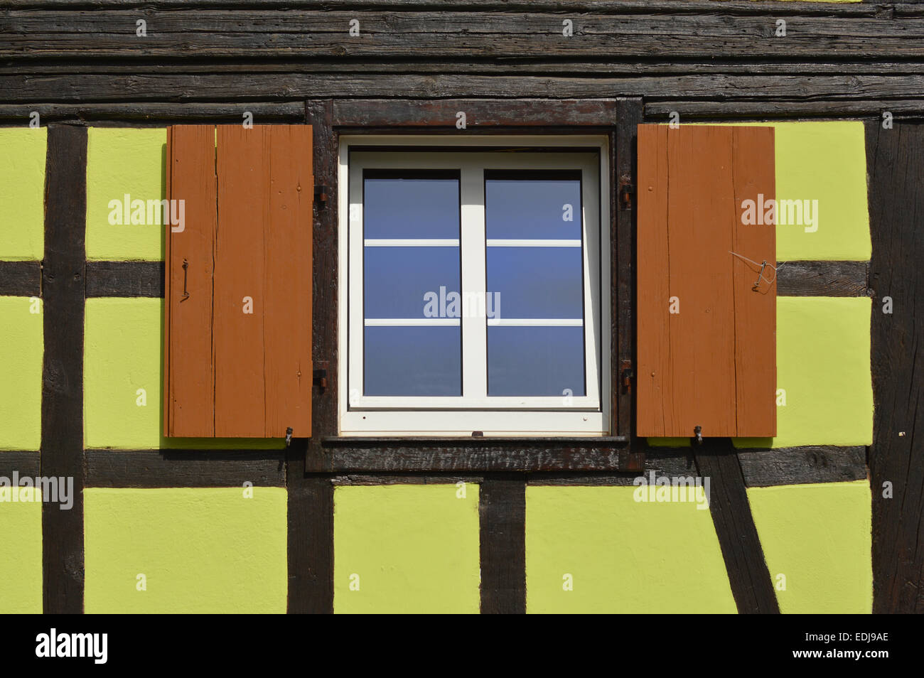 Green timberframe house - Window with wooden shutters Exterior green painted  timbered house in the Alsace, France Stock Photo