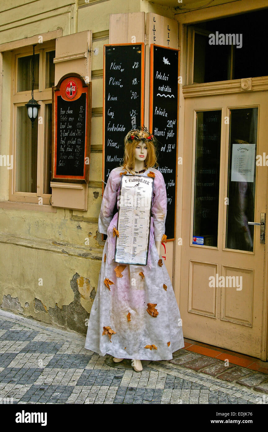 Female mannequin, in costume, holding a menu outside a restaurant in Prague, Czech Republic Stock Photo