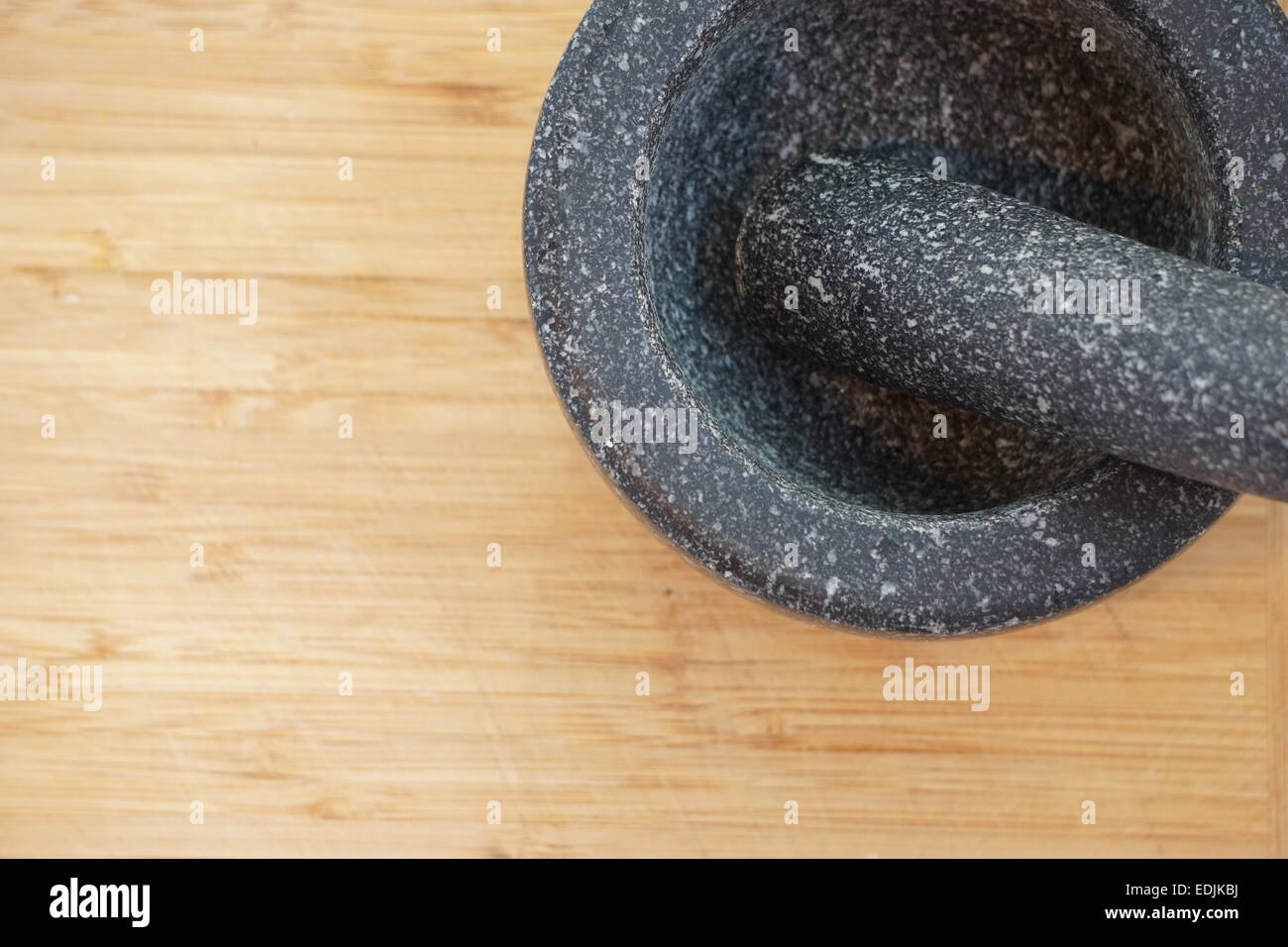Mortar and pestle on wooden chopping board. Stock Photo