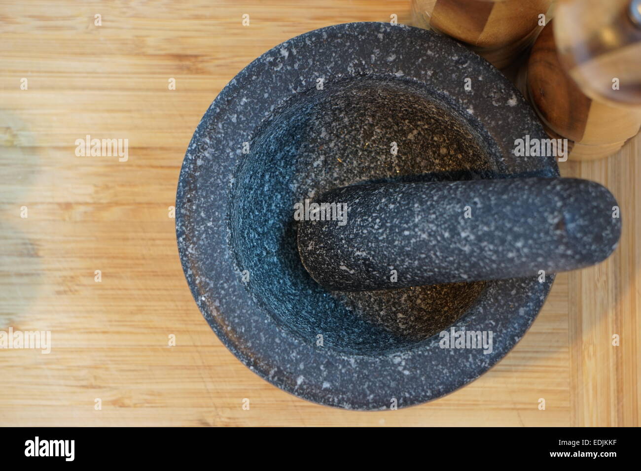 Mortar and pestle on wooden chopping board. Stock Photo