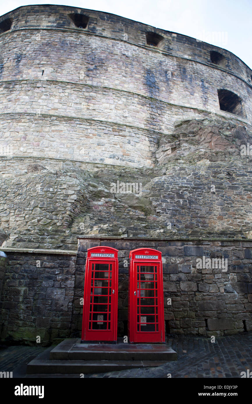 Two iconic red British Telephone boxes under the historical wall of Edinburgh Castle, Scotland. Stock Photo