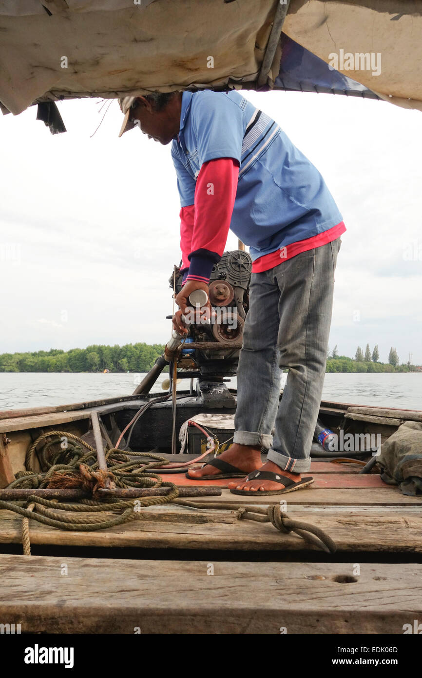 Thai Long-tail boat driver, controlling the lever stick of engine, Krabi, Thailand, Southeast Asia. Stock Photo