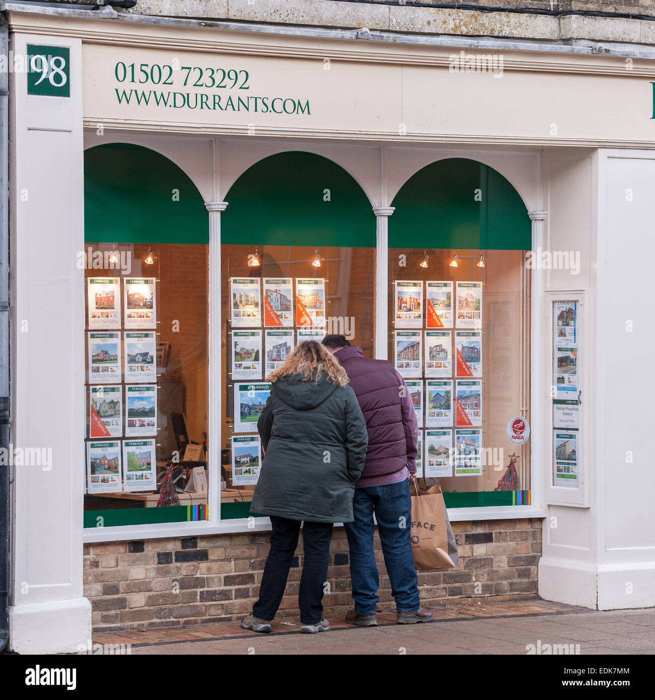 People looking in the window of Durrants Estate Agent at Southwold , Suffolk , England , Britain