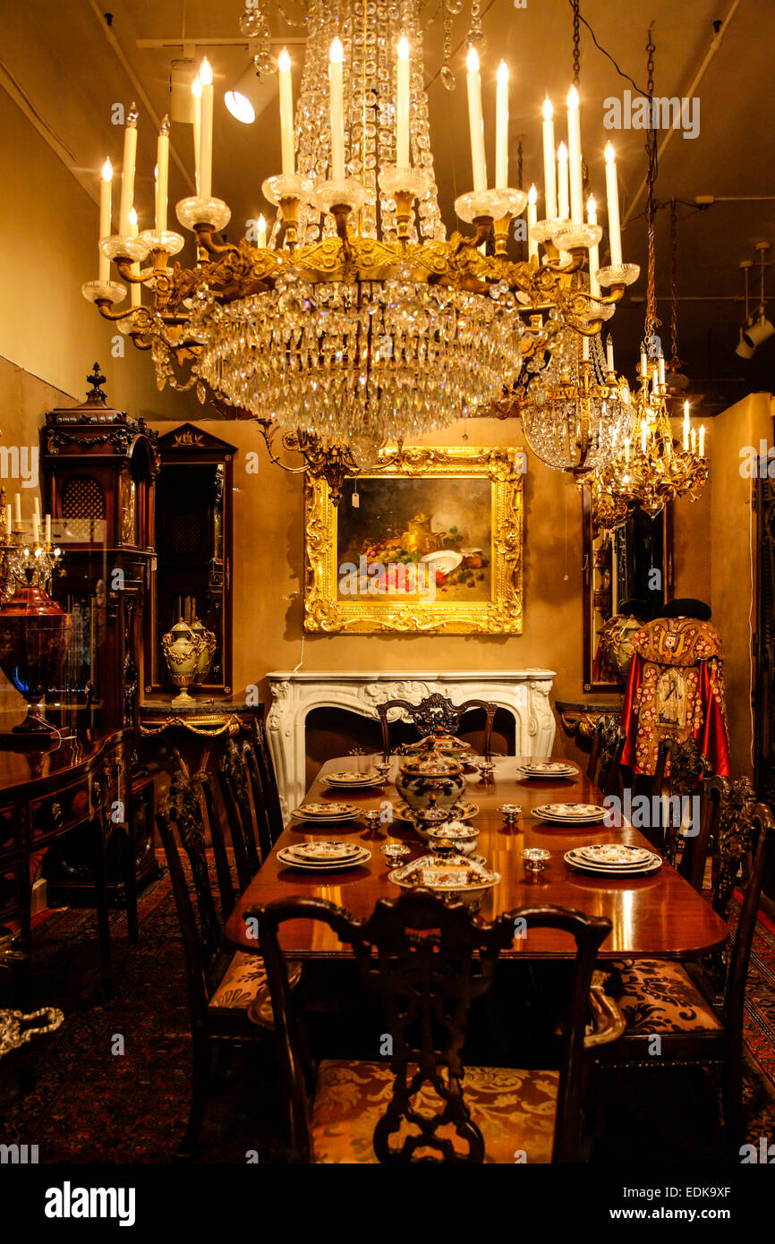 A colonial house dining room with chandelier and art work on display, a store window display on Royal Street in New Orleans LA Stock Photo