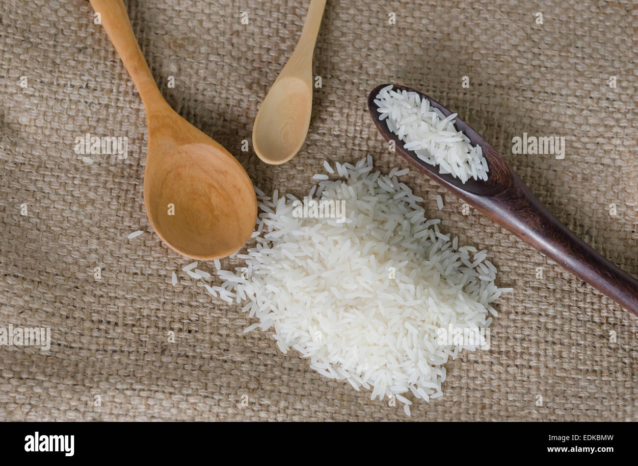 white rice grains with wooden spoon on sackcloth Stock Photo - Alamy