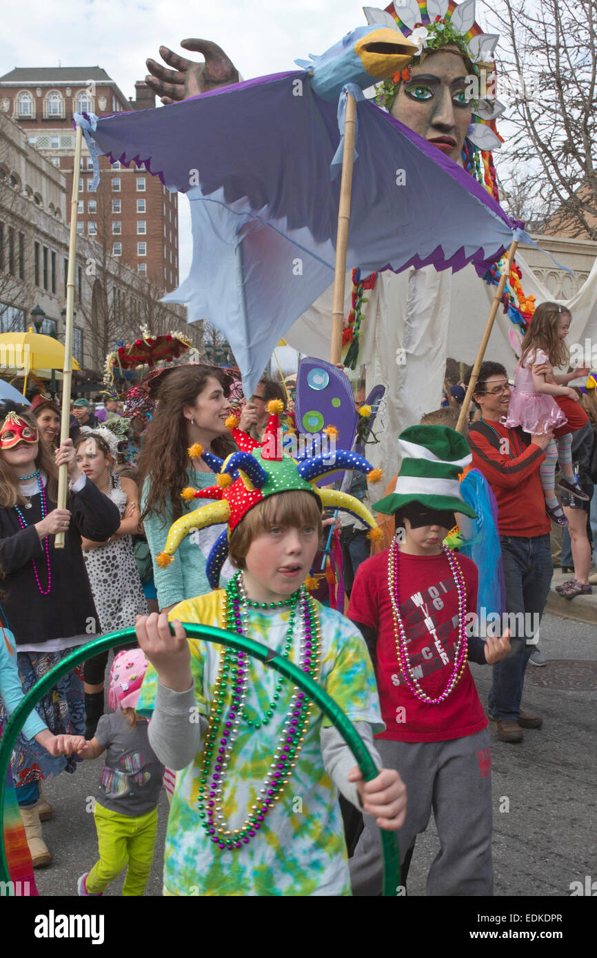 A happy crowd in colorful costumes and creative floats participate in the Asheville, NC Mardi Gras parade Stock Photo