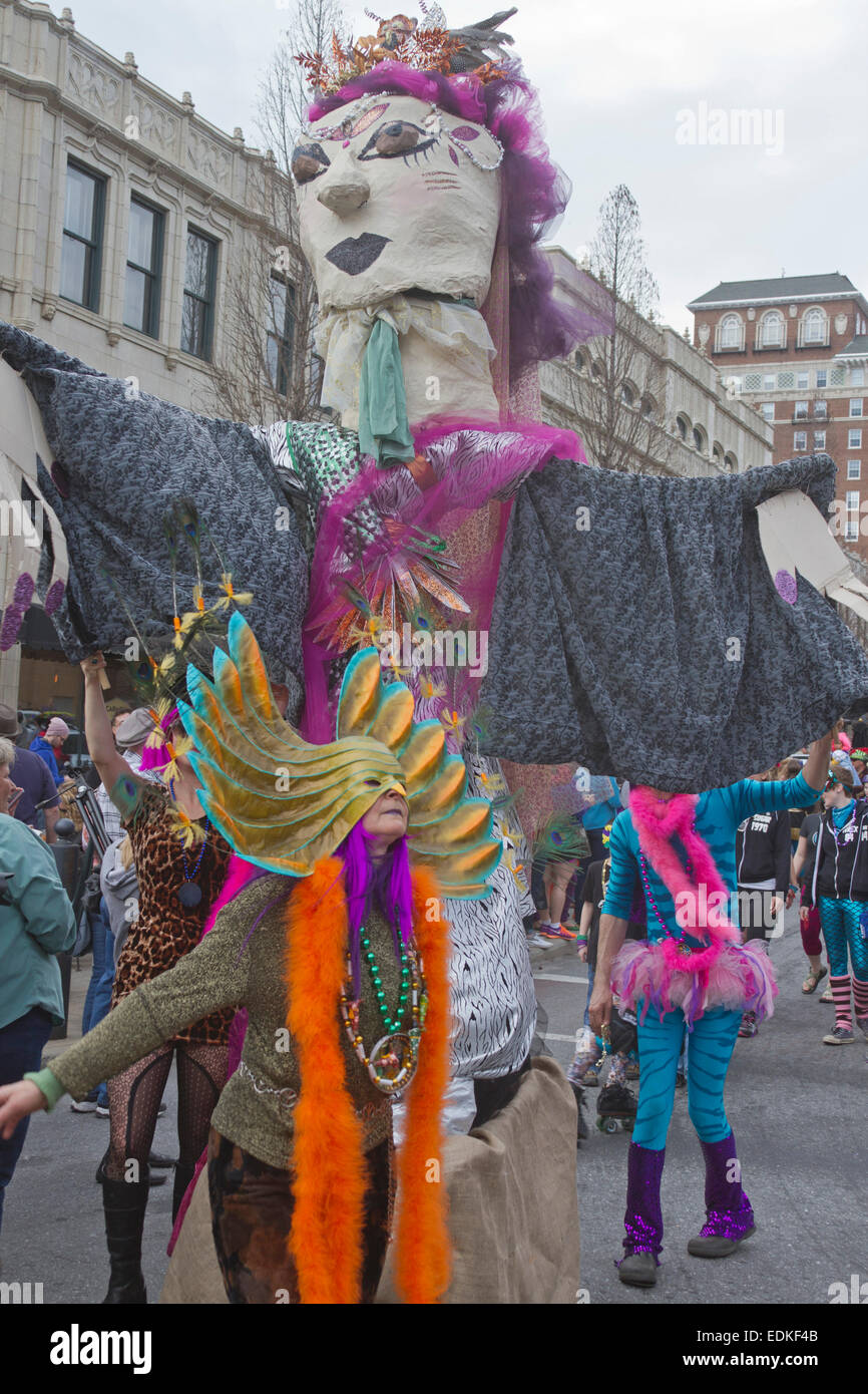 Happy people in colorful costumes with a creative effigy participate in the Asheville, NC Mardi Gras parade Stock Photo