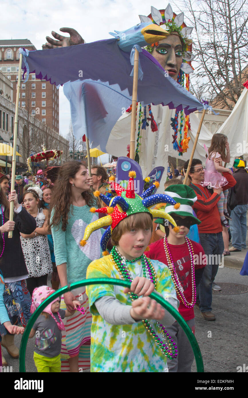 A happy crowd in colorful costumes and creative floats participate in the Asheville, NC Mardi Gras parade Stock Photo