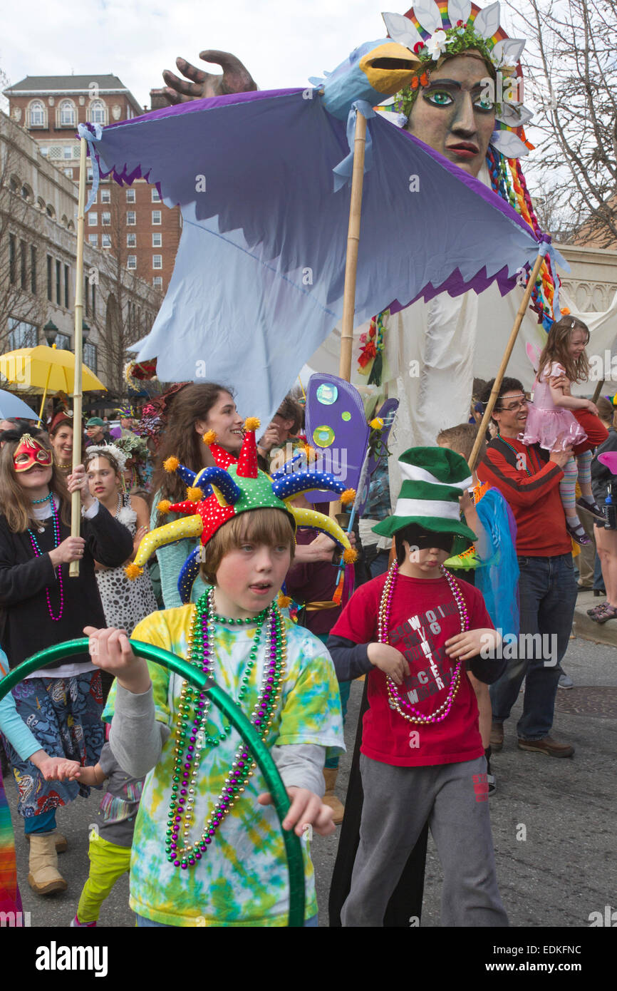 A happy crowd in colorful costumes and creative floats participate in the Asheville, NC Mardi Gras parade Stock Photo