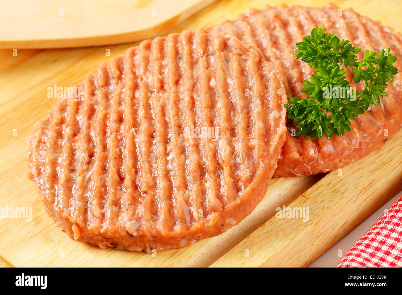 Raw burger patties on cutting board Stock Photo