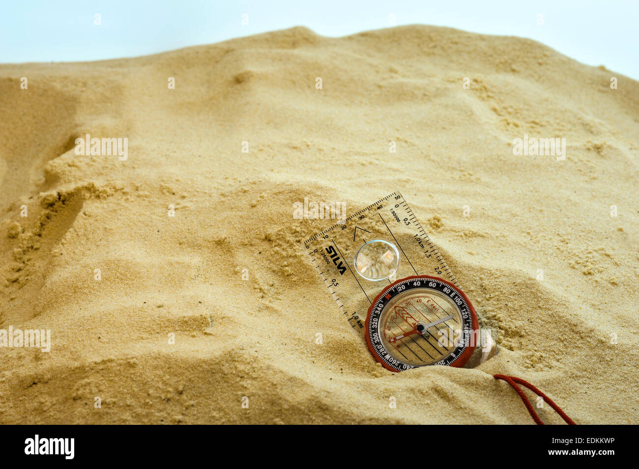 Compass buried in sand. Stock Photo