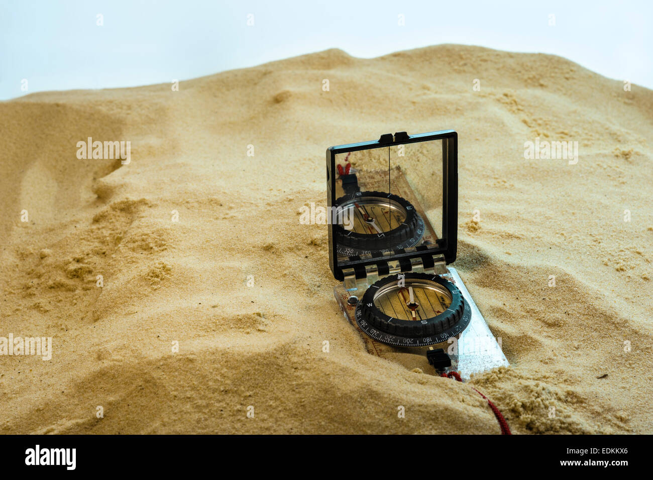 Compass buried in sand. Stock Photo