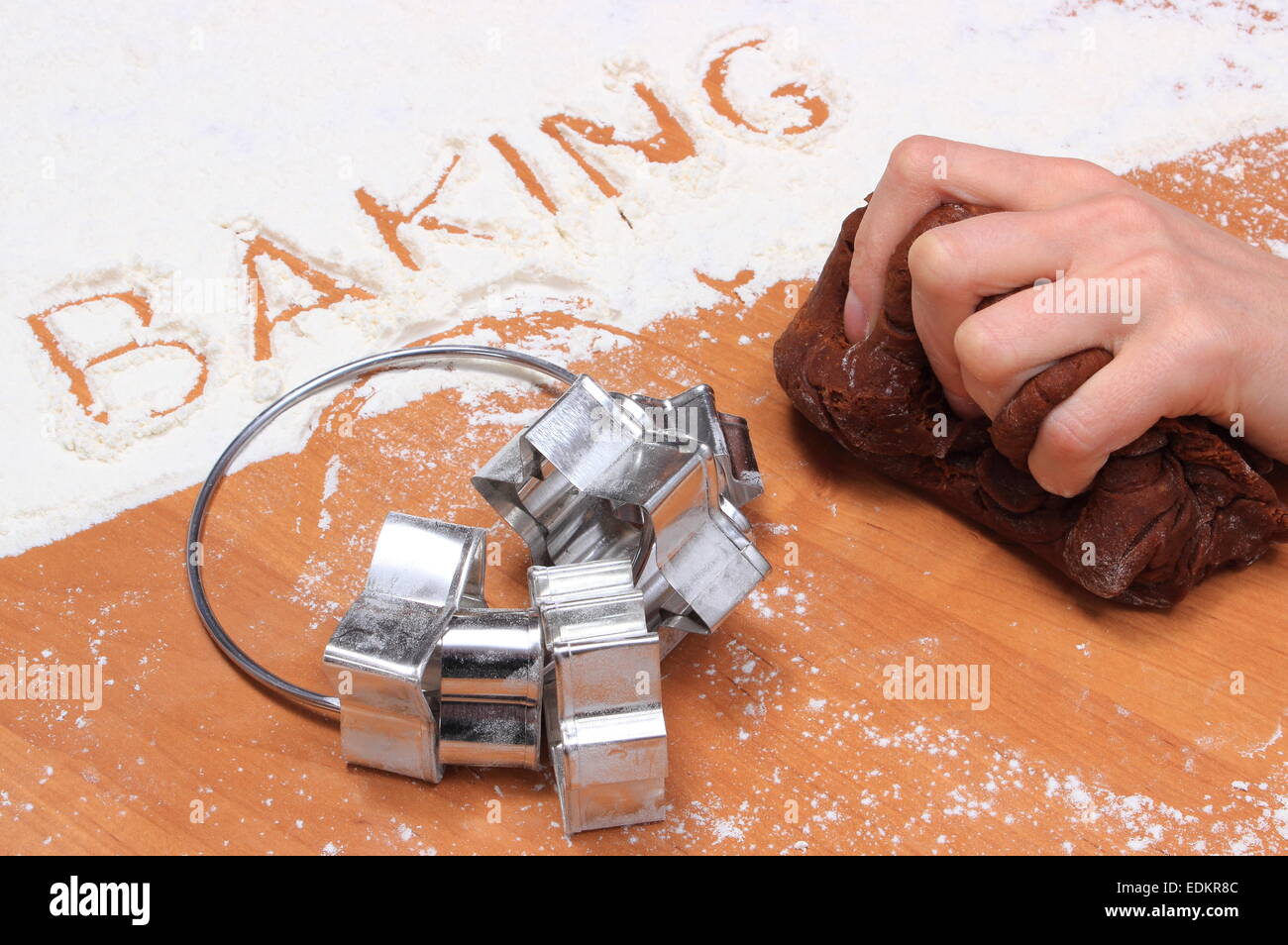 Hand of woman kneading dough for Christmas cookies, word baking in white flour and accessories for baking, concept for baking Stock Photo