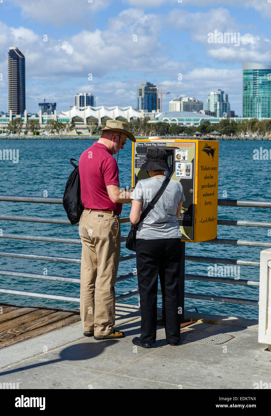 Couple buying ferry tickets from a pay station on the pier in Coronado, San Diego, California, USA Stock Photo