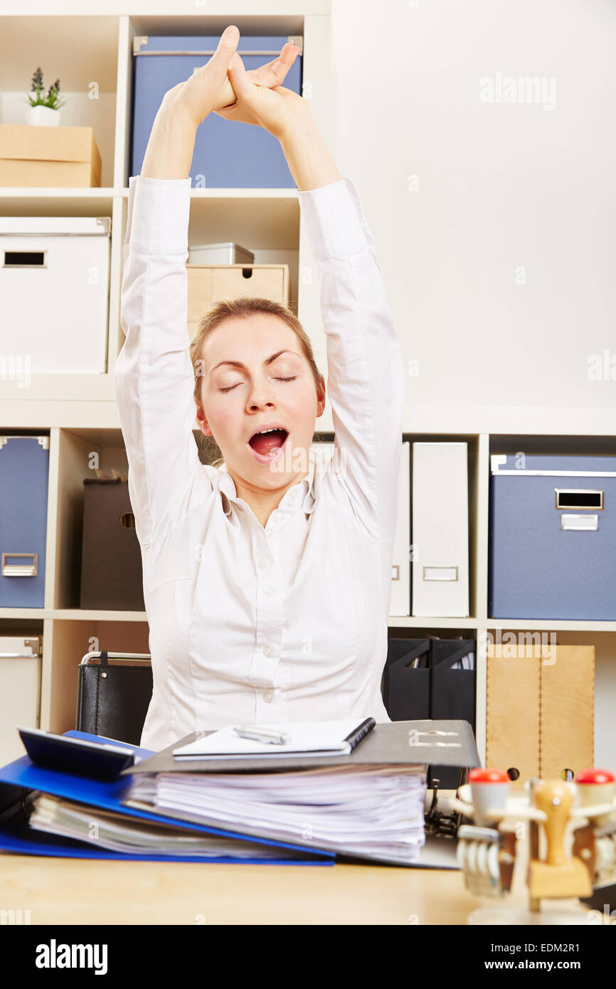 Tired fatigue business woman yawning and stretching in her office Stock Photo