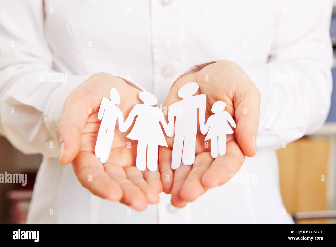 Paper family protected safe in two female hands Stock Photo