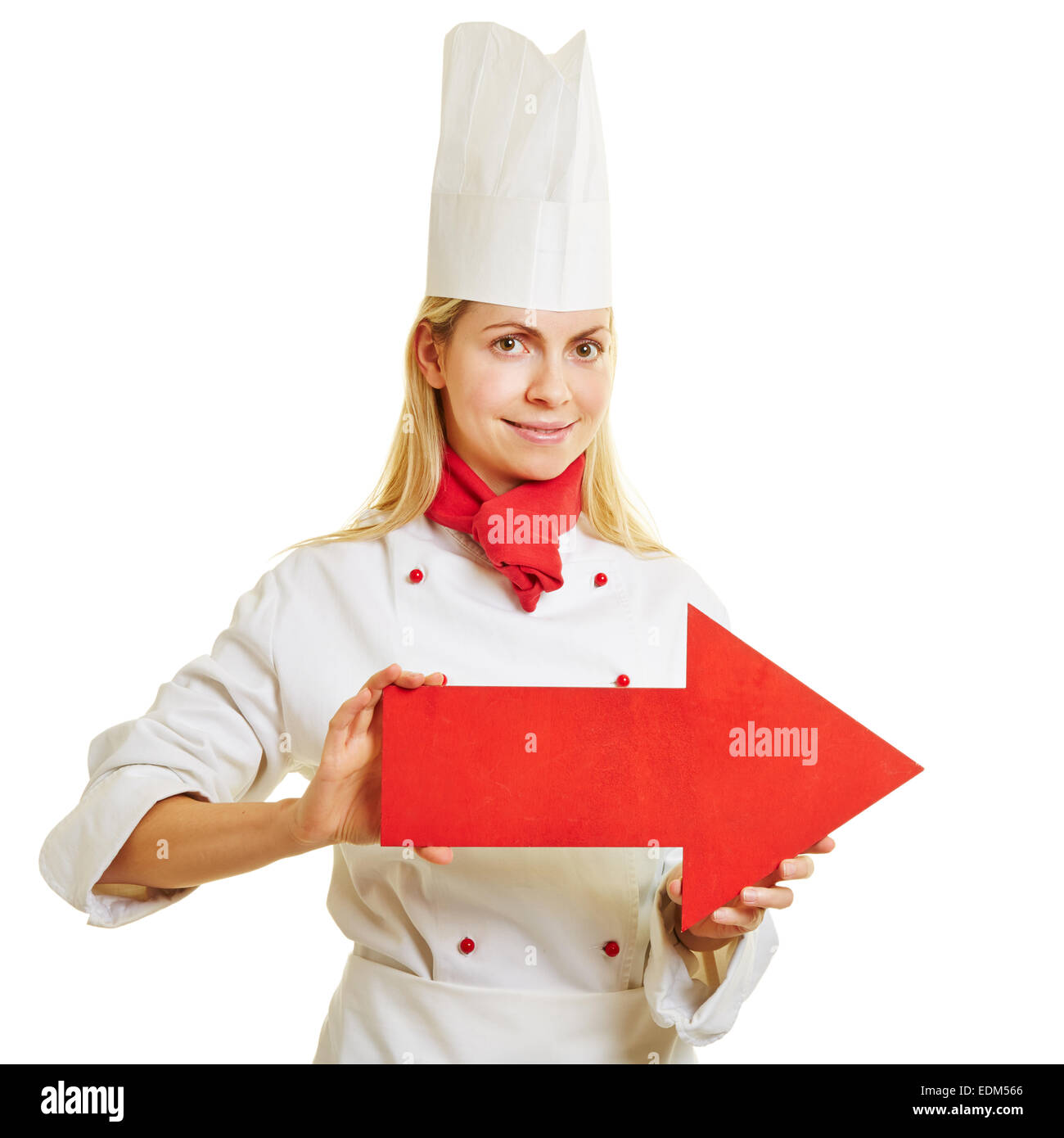 Smiling female cook in apprenticeship holding a big red arrow to the right Stock Photo