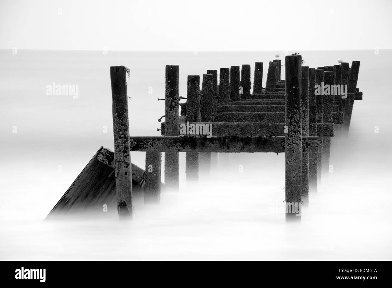 Black and white long exposure of the old sea defences at Happisburgh in Norfolk, England UK Stock Photo