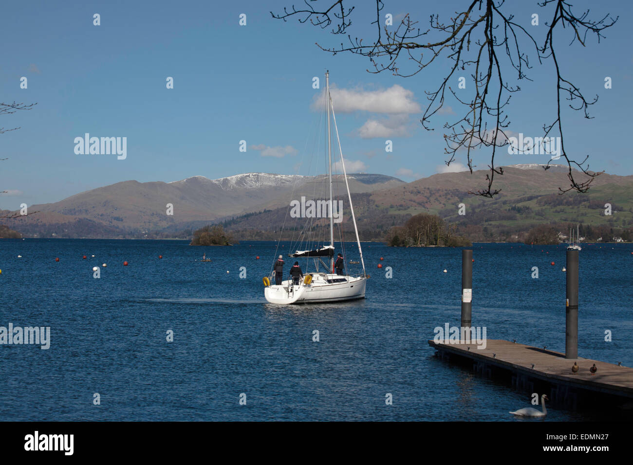 Yacht sailing on Windermere with The Fairfield Horseshoe above Ambleside in background Bowness Windermere Lake District Cumbria Stock Photo