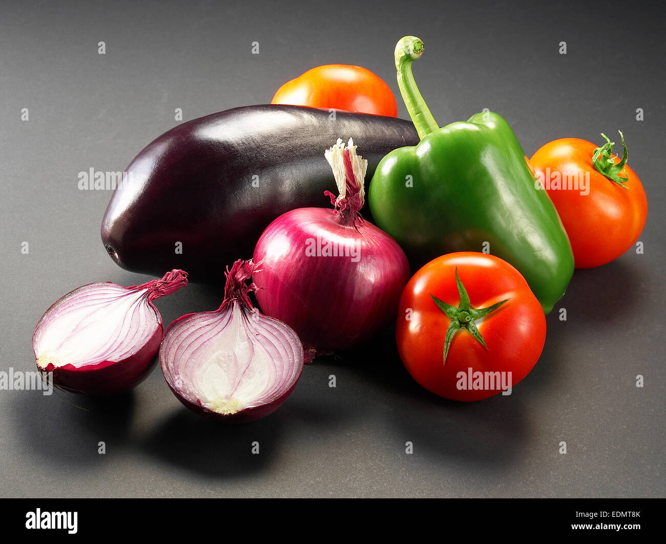Still life photography of vegetables; peppers, onions, tomatoes, eggplant Stock Photo
