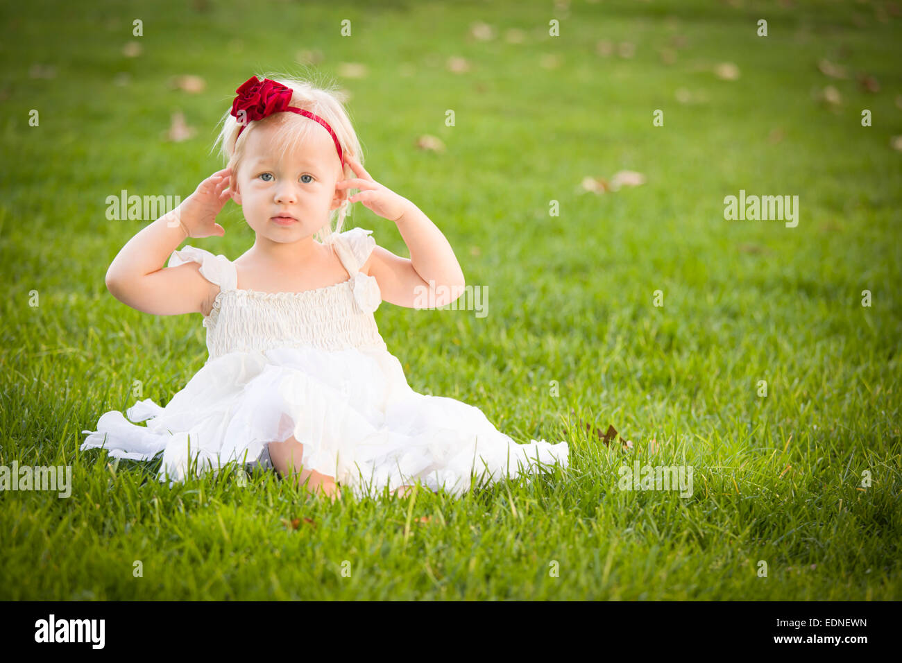Beautiful Adorable Little Girl Wearing White Dress Sitting In A Grass ...