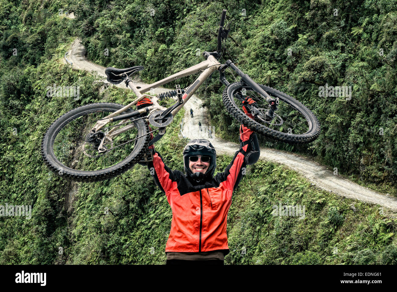 Mountain biker pulls up his mountain bike at the famous downhill trail 'Road of death' in Bolivia. Stock Photo