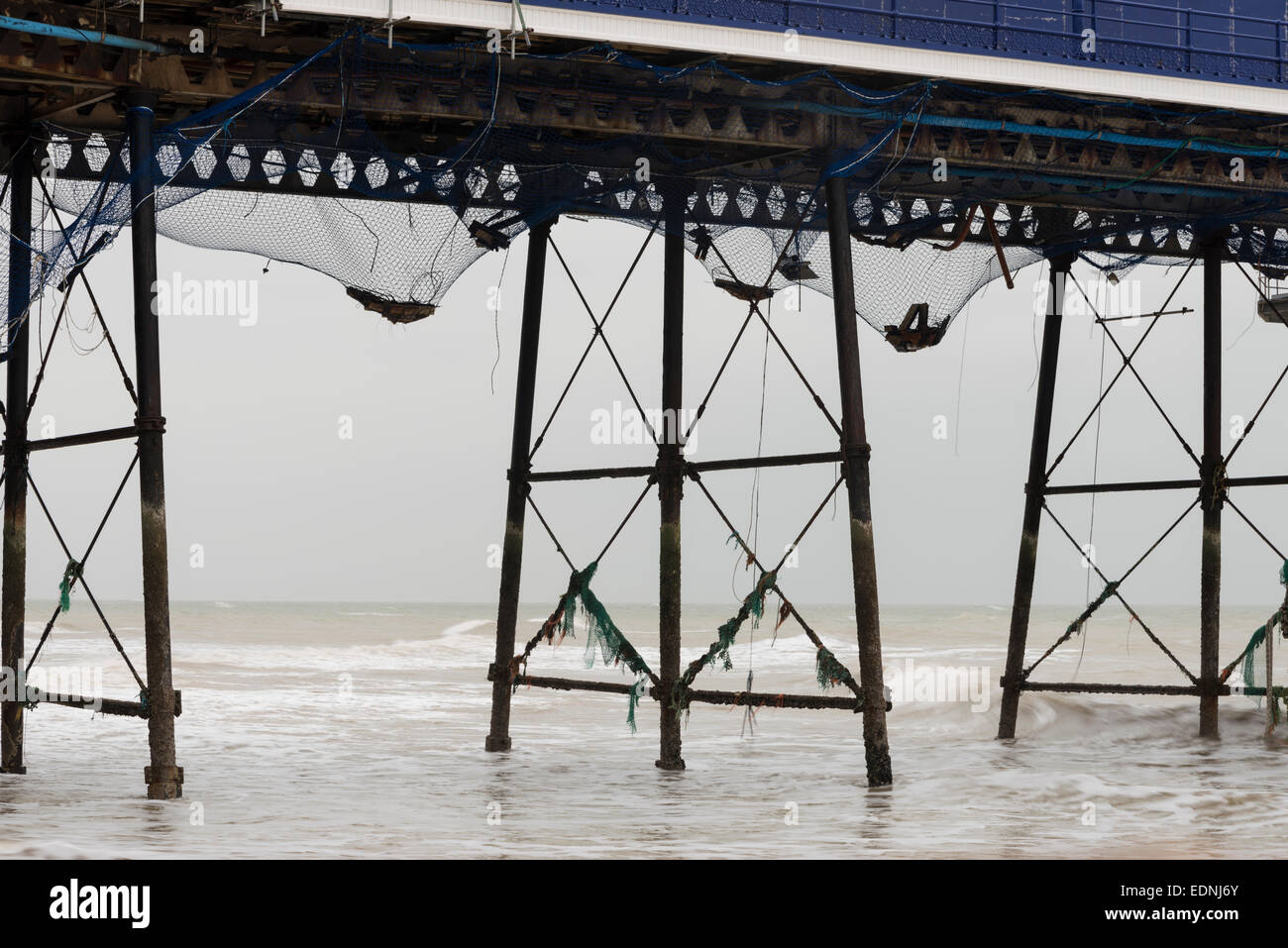 The Victorian iron struts and legs of Eastbourne Pier, a grade II* listed building and netting added after the fire in Sept 2014 Stock Photo