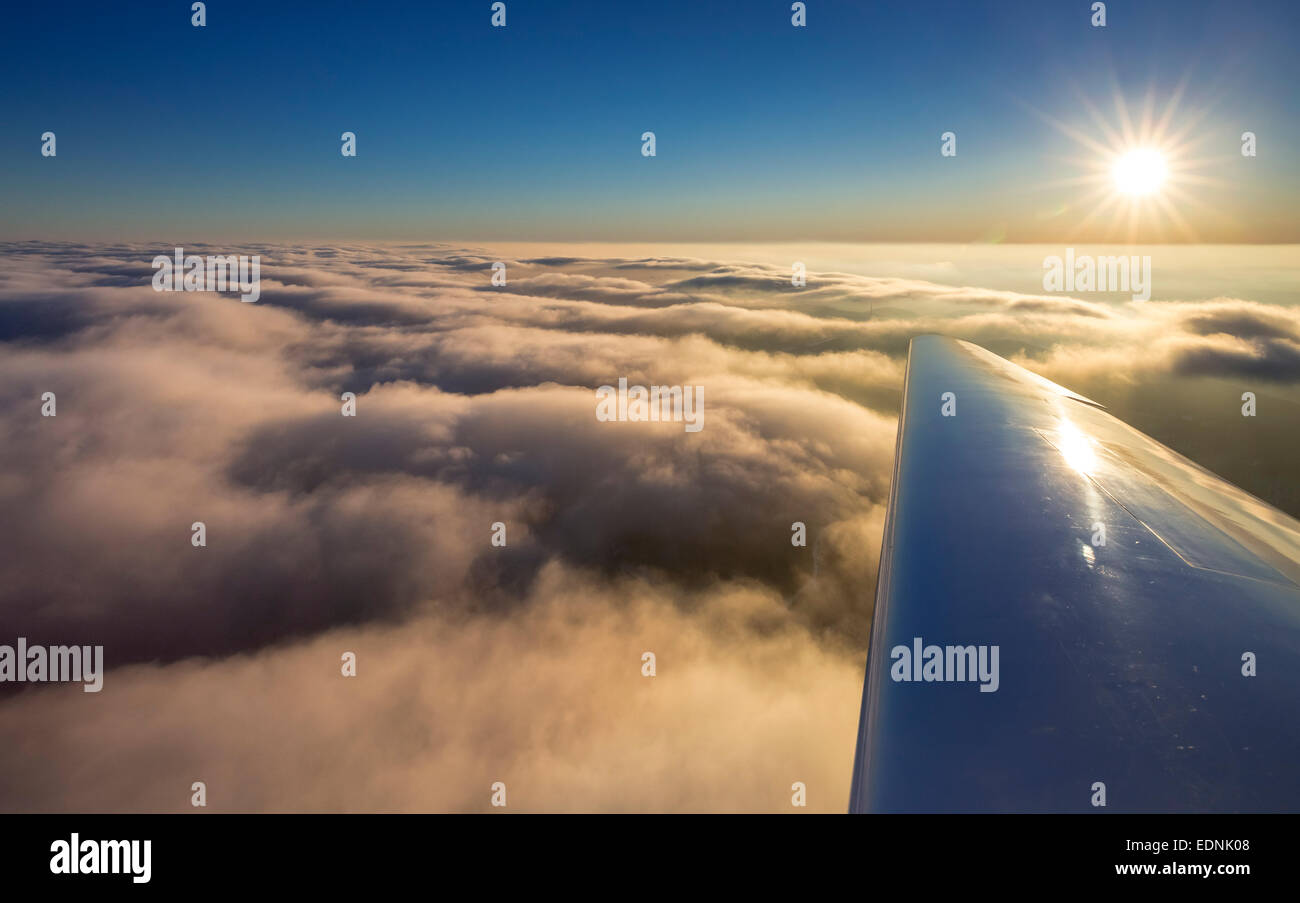 Cloud cover above Winterberg, right wing of airplane, sunset, blue sky, Winterberg, Hochsauerland district, Sauerland Stock Photo