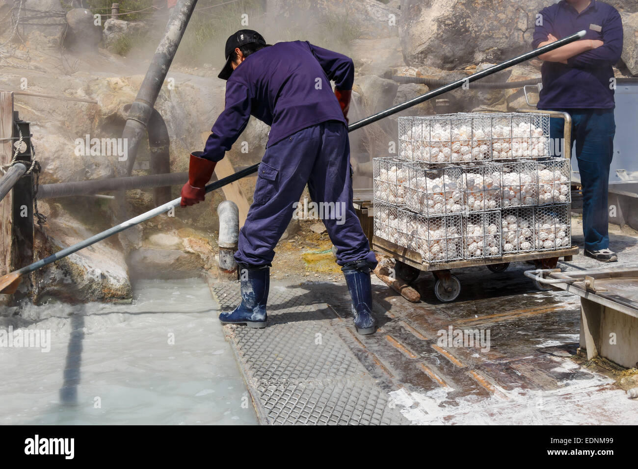 Worker is boiling eggs in mineral water at Owakudani valley ( volcanic valley with active sulphur vents and hot springs in Hakon Stock Photo