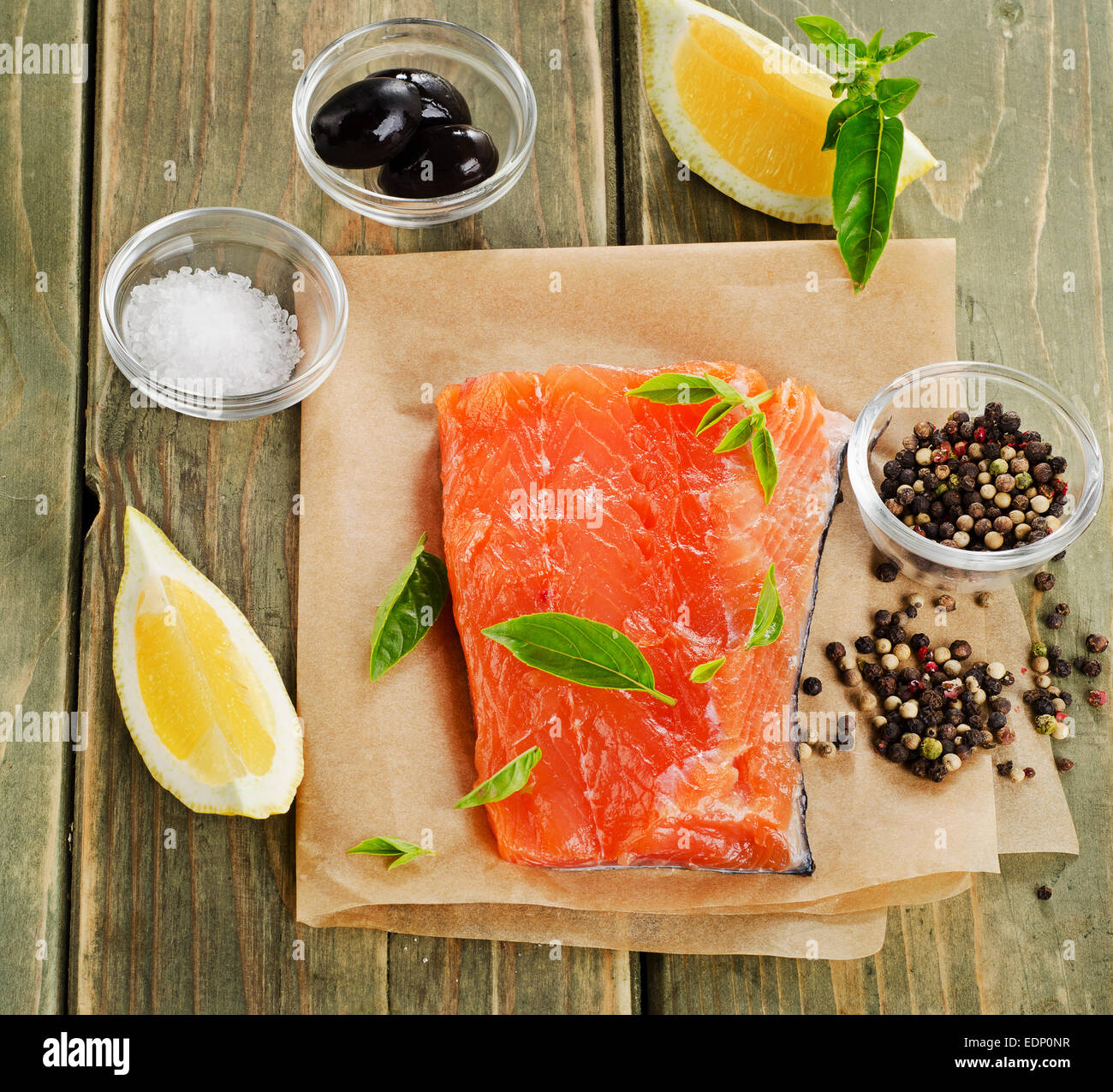 Salmon on a wooden board with lemon and herbs . Stock Photo