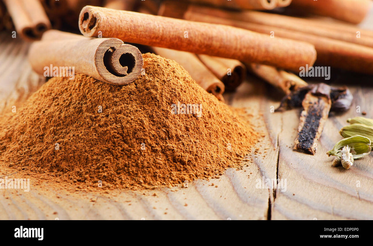 Cinnamon sticks and powder on wooden table. Selective focus Stock Photo