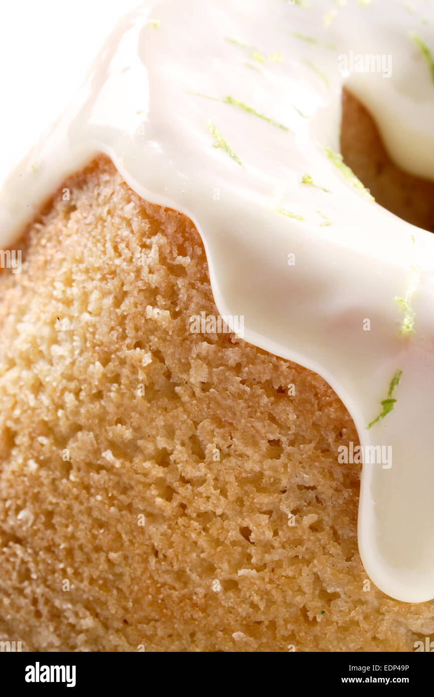 A close up of a lemon sponge cake with icing and lime rind Stock Photo