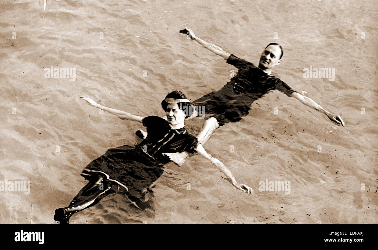Man and woman floating on their backs in water, Couples, Swimming, 1900 Stock Photo