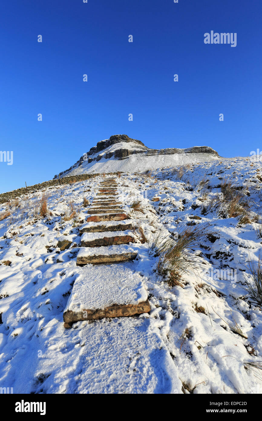Stone steps leading to a snowy Pen-y-ghent on the Pennine Way, Yorkshire Dales National Park, North Yorkshire, England, UK. Stock Photo