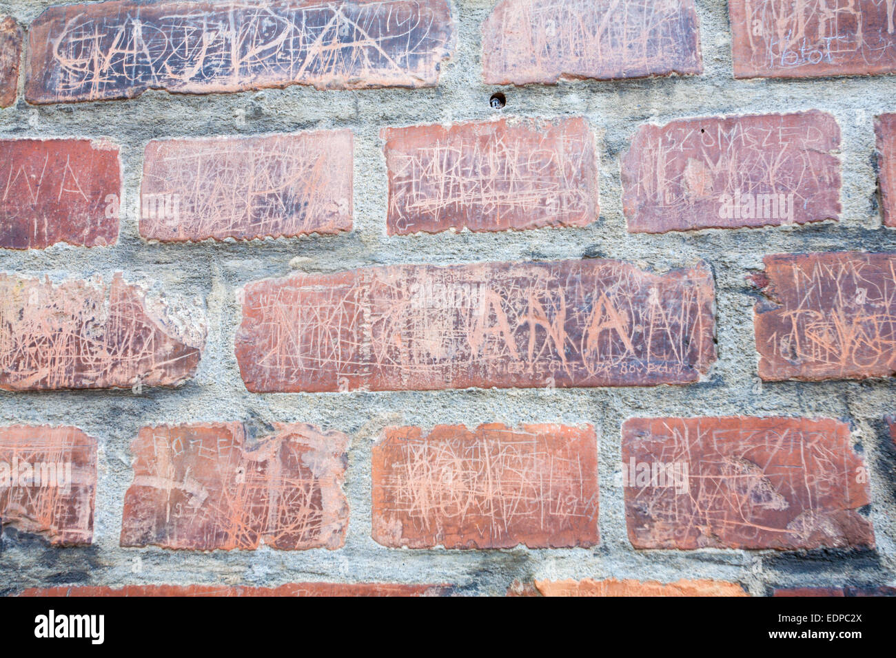 Names scratched on brick wall at the Auschwitz concentration camp, Auschwitz, Poland Stock Photo