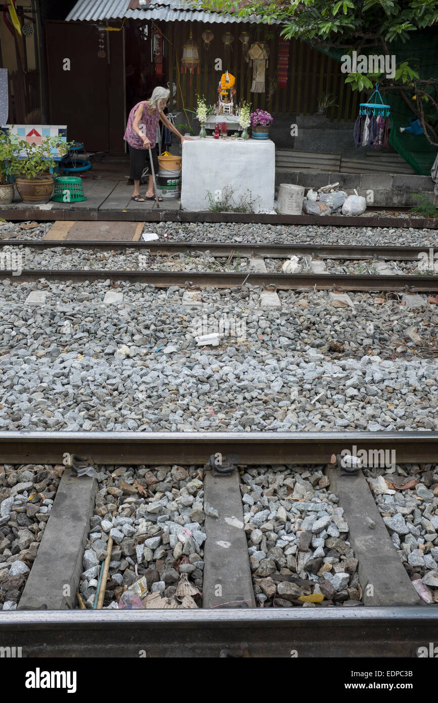 Old Lady living alongside the railway tracks in downtown Bangkok Stock ...