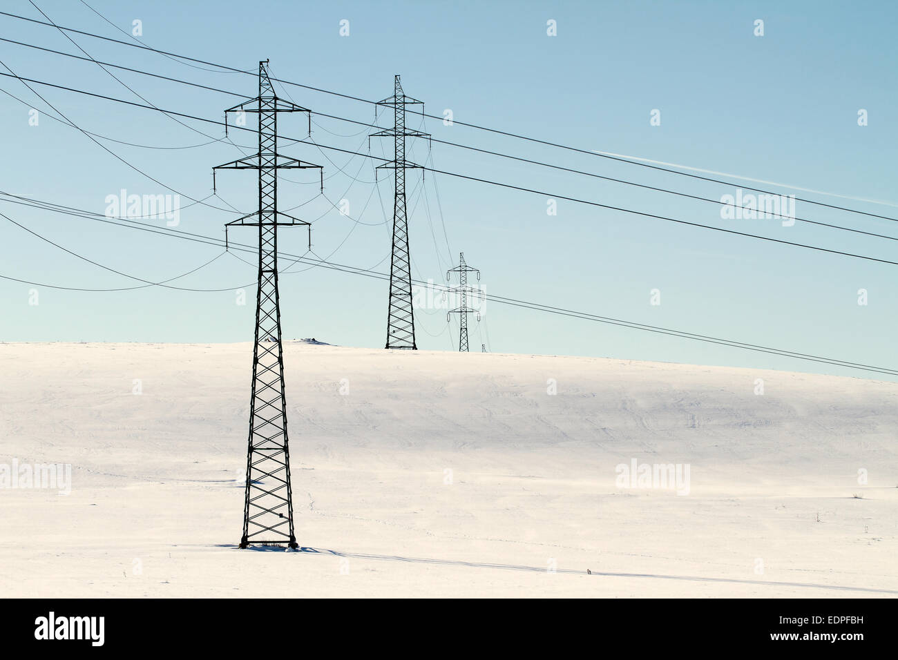 High voltage electricity power pylon on snowy field Stock Photo - Alamy