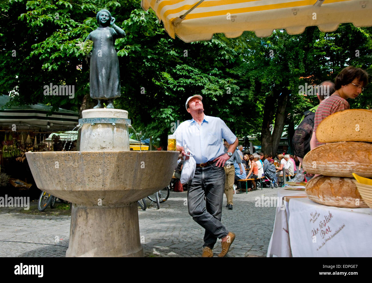 Munich, Bavaria, Germany. Vitualienmarkt - Statue of Liesl Karlstadt (actress). Man with beer enjoying the sun Stock Photo