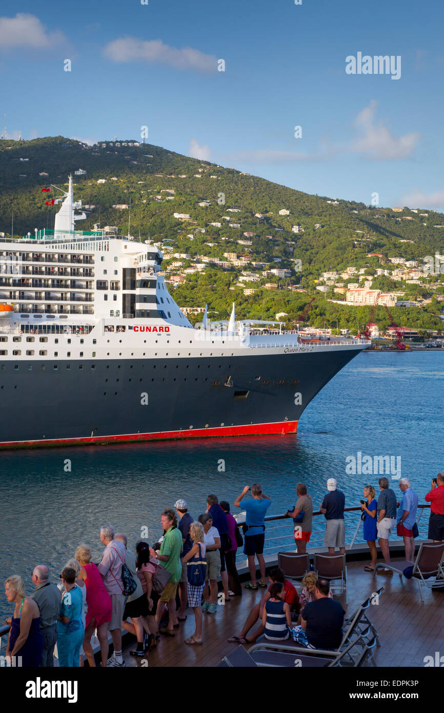 Passengers aboard Cruise ship view the Queen Mary II Cruise Ship docked in Charlotte Amalie Harbor, St Thomas, US Virgin Islands Stock Photo