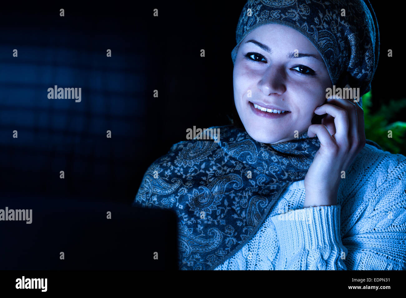 Smiling Middle Eastern Woman with Computer and Headset at Night Stock Photo