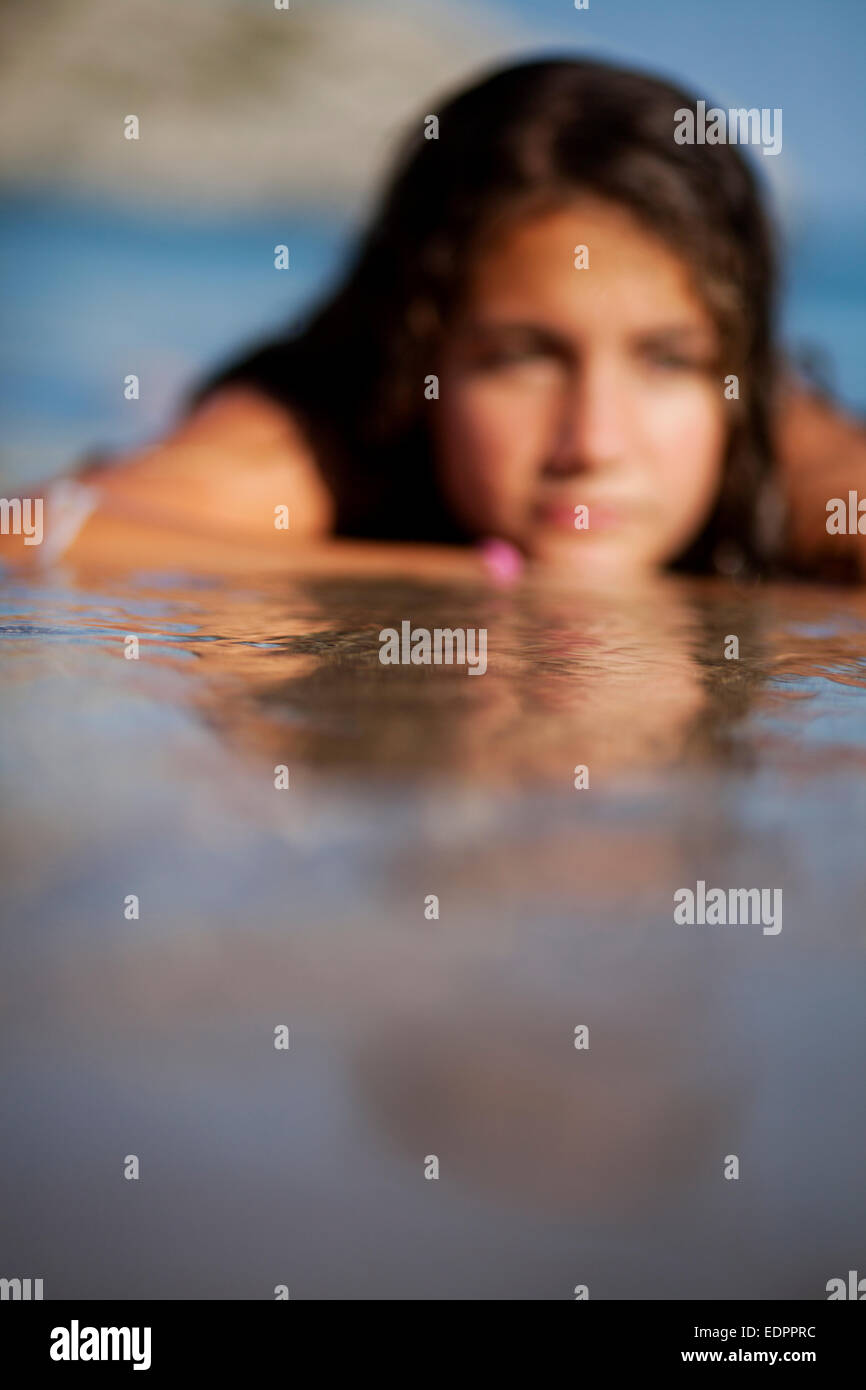 Blurred teenager girl at the shore daydreaming in the water Stock Photo