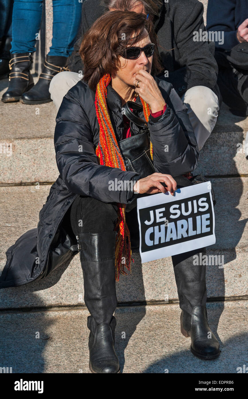 Geneva, Switzerland. 8th January 2015. A sad or pensive woman holding a sign of support during a vigil in Geneva's Place de Neuve to show solidarity with the victims of the attack against Charlie Hebdo. Credit:  Alistair Scott/Alamy Live News Stock Photo