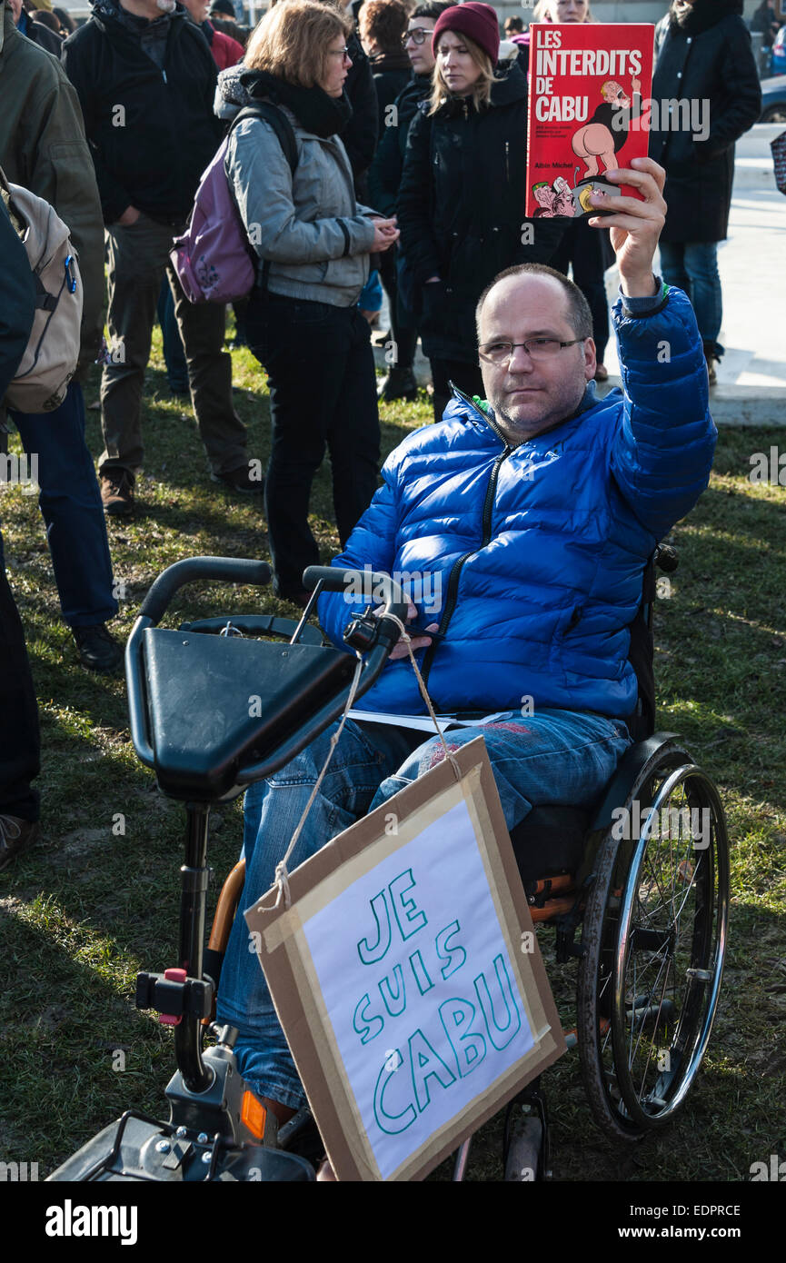 Geneva, Switzerland. 8th January 2015. A disabled journalist attending a vigil in Geneva's Place de Neuve to show solidarity with the victims of the attack against Charlie Hebdo. He is holding up a book by murdered cartoonist Jean Cabu Credit:  Alistair Scott/Alamy Live News Stock Photo
