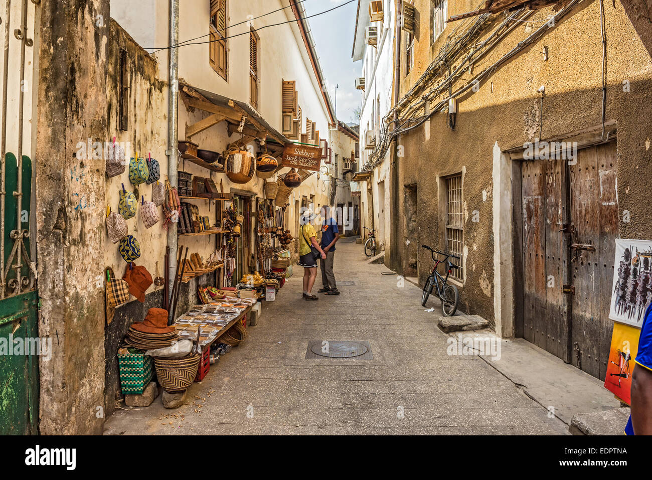 Tourists on a typical narrow street in Stone Town, Zanzibar Stock Photo