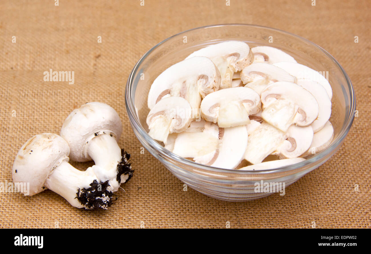 Sliced mushrooms in bowl on placemat jute Stock Photo