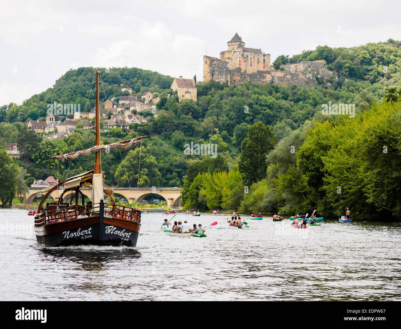 A tourist boat, in French called 'gabare', left, together with kayaks and canoes on the river Dordogne at Castelnaud-la-Chapelle Stock Photo