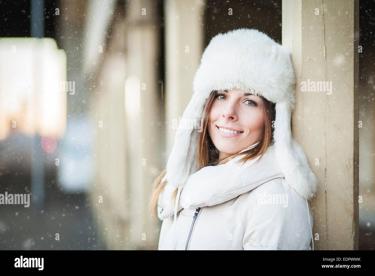 Girl in white hat and warm jacket in winter cold Stock Photo