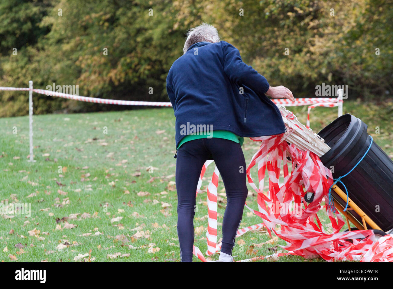 After a cross country running race a senior man packs up course markers After a cross country running race a senior man packs up course markers