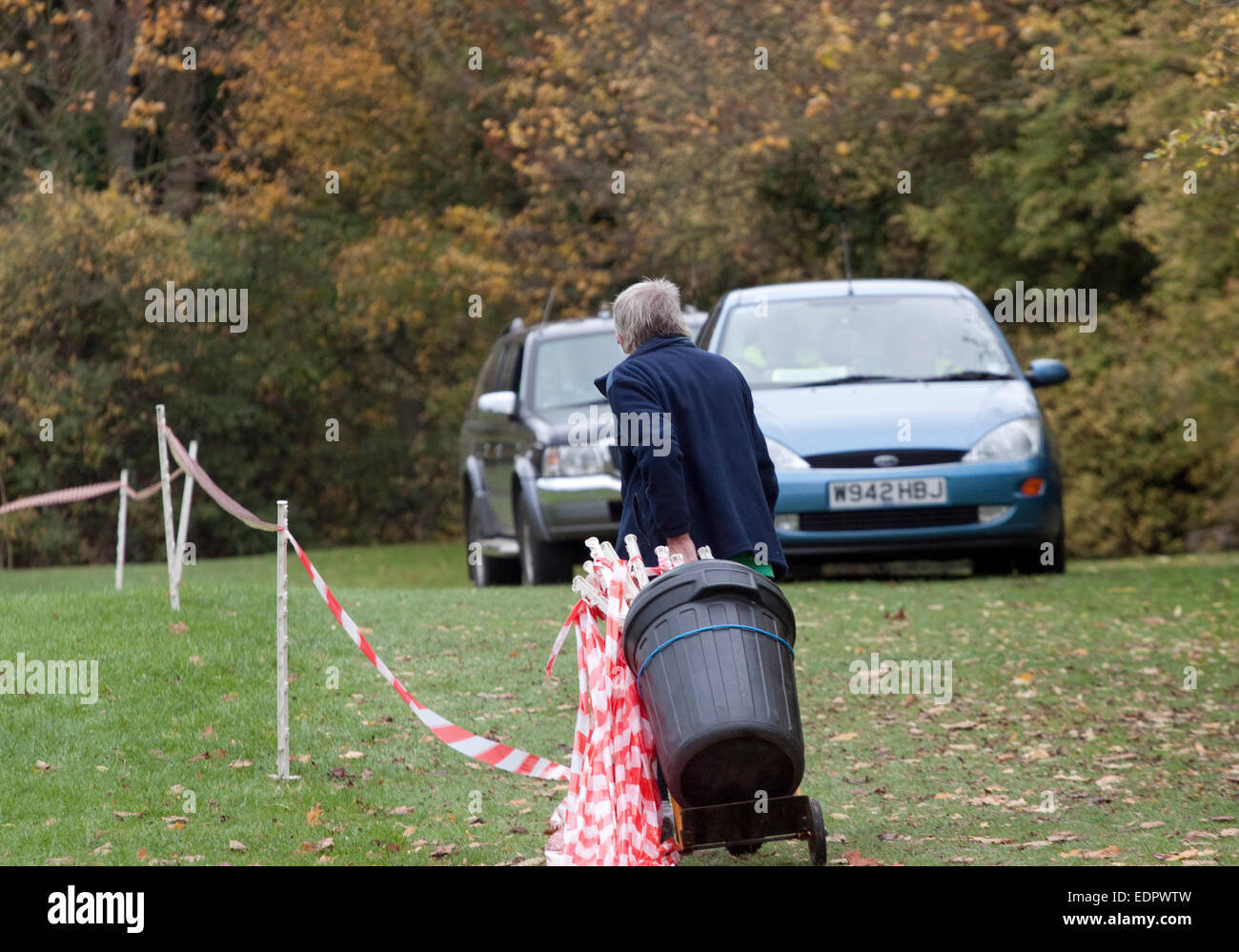 After a cross country running race a senior man packs up course markers After a cross country running race a senior man packs up course markers