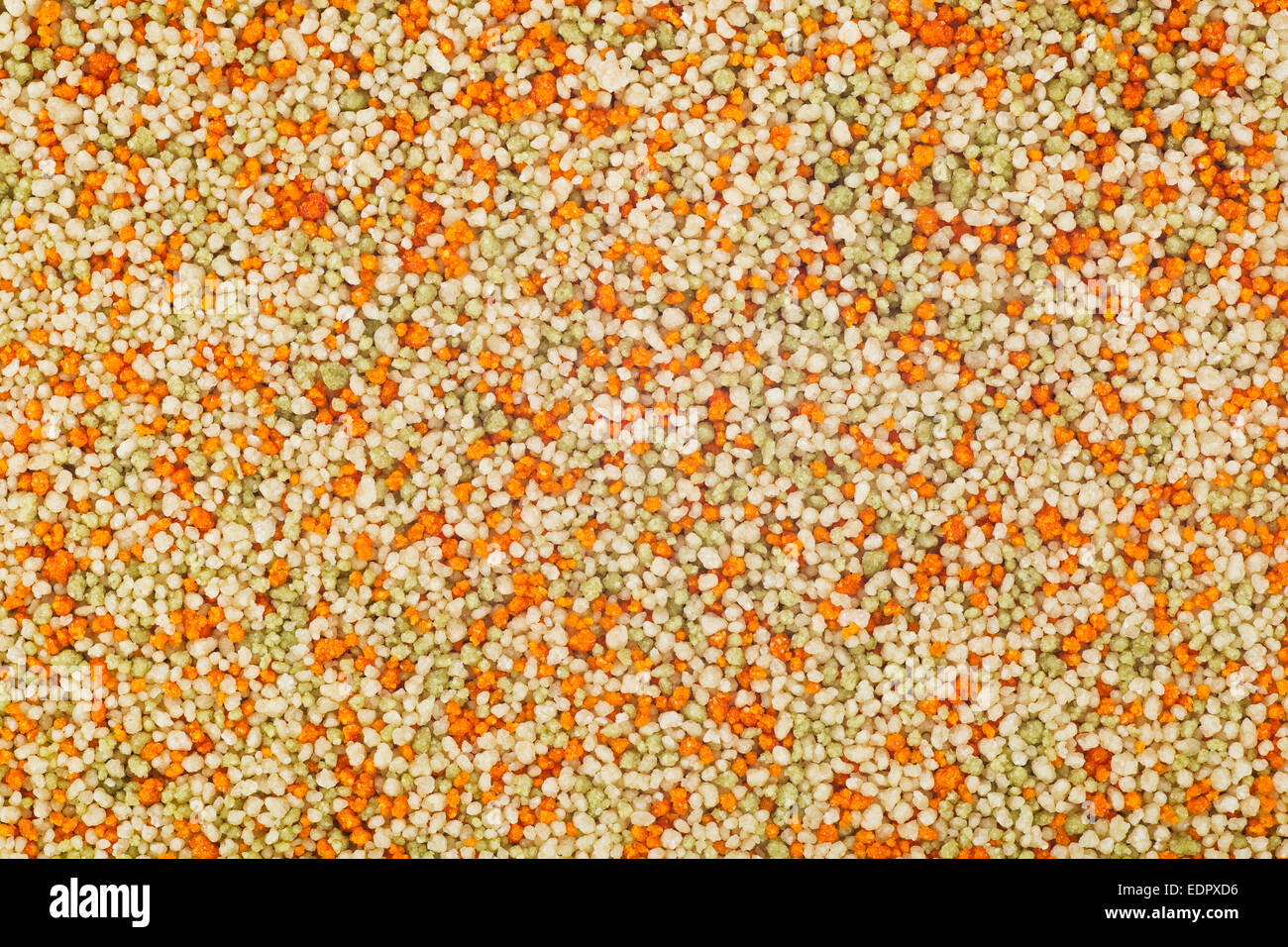 Tricolor couscous food texture or background, with tomato and spinach flavor Stock Photo